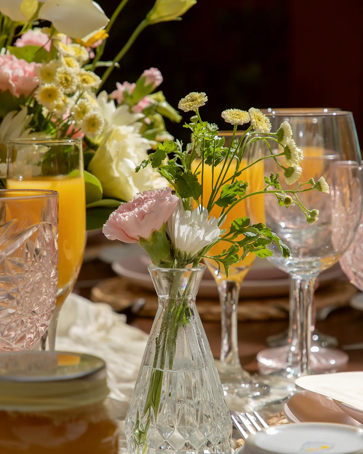 Cristalería y flores de temporada en la mesa de una comida de día