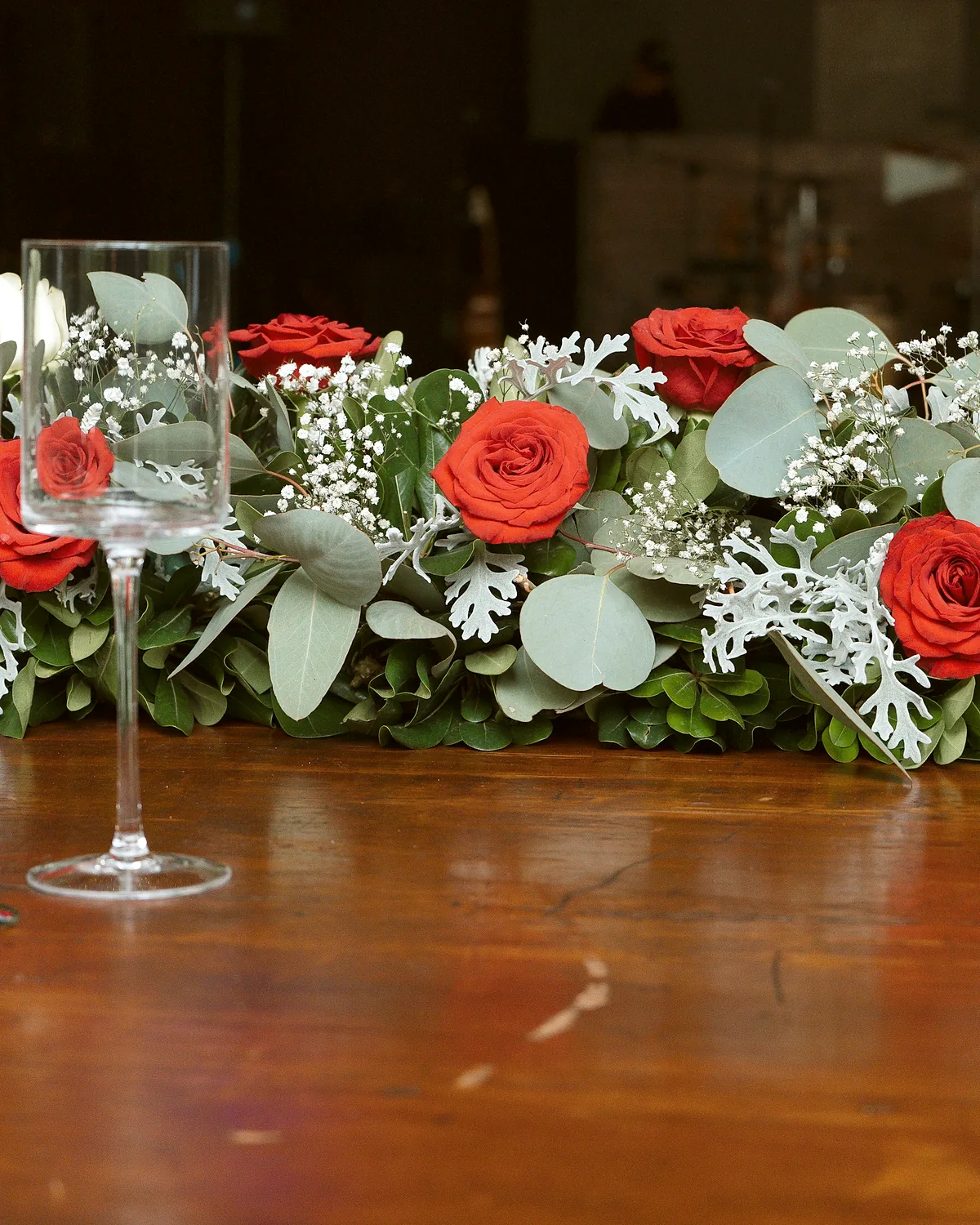 Camino de rosas rojas sobre la mesa imperial de madera