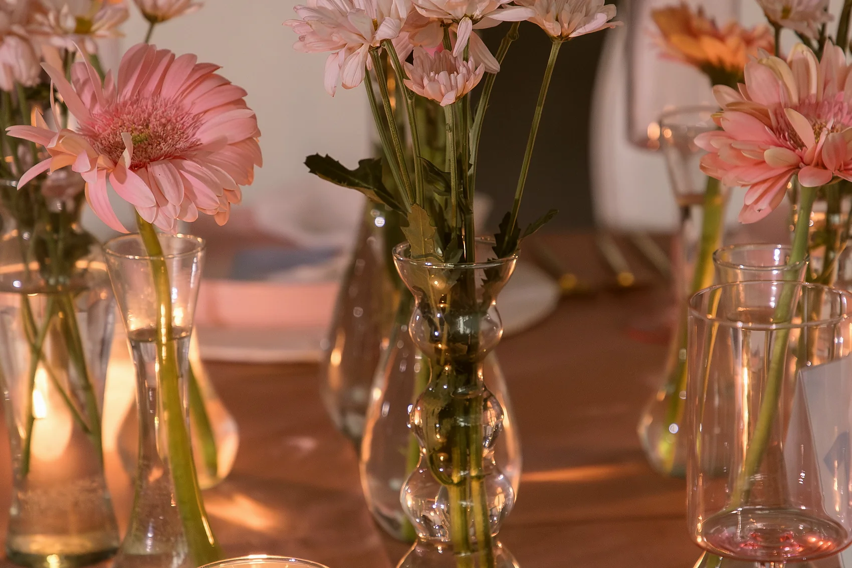 Arreglos de flores rosas y veladoras sobre la mesa, al caer la tarde
